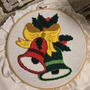 vintage Christmas punch needle embroidery piece featuring bells and holly